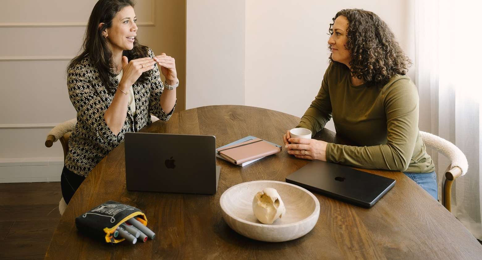 Iris in gesprek met een cliënt aan een ronde tafel in de praktijk