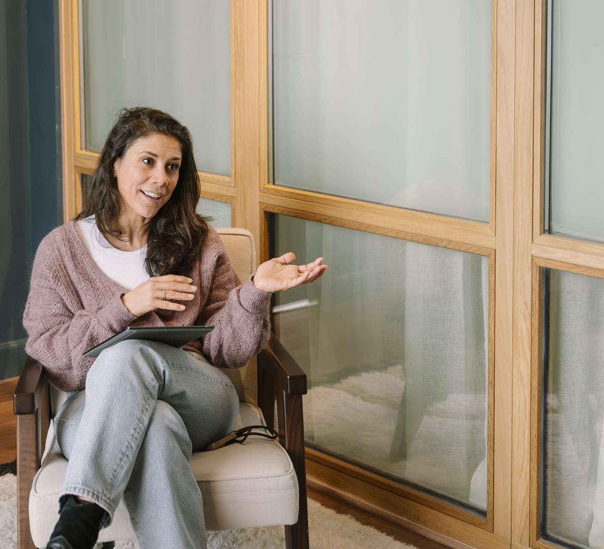 Iris in een roze vest in gesprek met een cliënt bij het raam